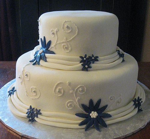 White Wedding Cake with Dark Blue Accents and Fondant Draping