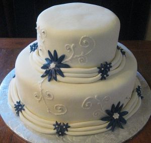 White Wedding Cake with Blue Flower Accents and Draping Fondant!